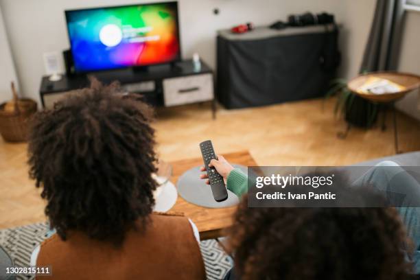 rear view of a happy african american family watching tv together - african american watching tv stock pictures, royalty-free photos & images