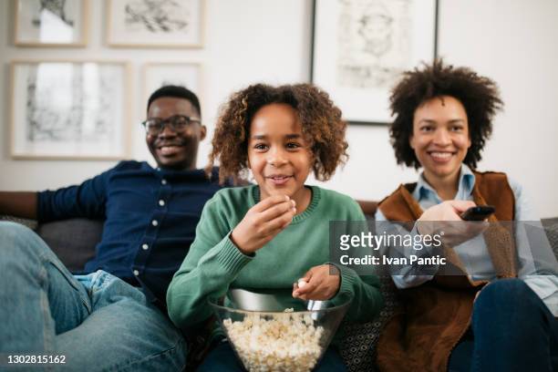 achteraanzicht van een gelukkige afrikaanse amerikaanse familie die samen tv kijkt - african family watching tv stockfoto's en -beelden