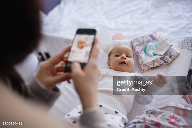 mother taking photos of her daughter with phone - photo messaging stock pictures, royalty-free photos & images