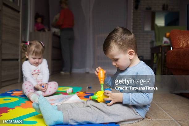 toddler boy with girl - sister and brother at home playing - latvia girls stock pictures, royalty-free photos & images