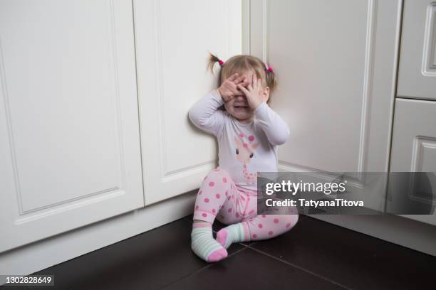 toddler girl covered her eyes with her hands and crying - woedeaanval stockfoto's en -beelden