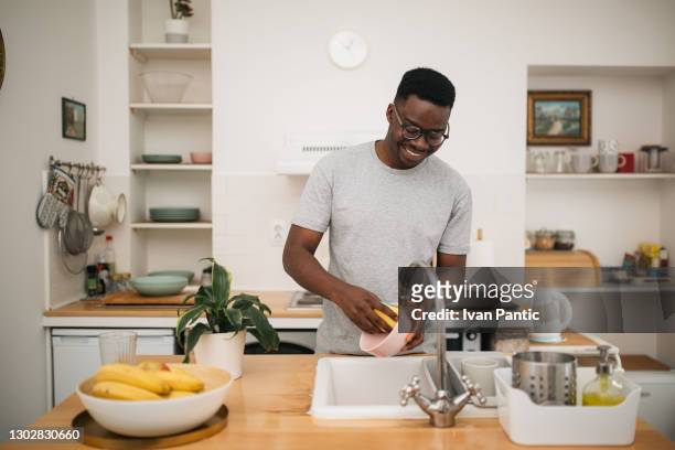 自宅で皿を洗う幸せなアフリカ系アメリ�カ人男性 - dirty dishes ストックフォトと画像
