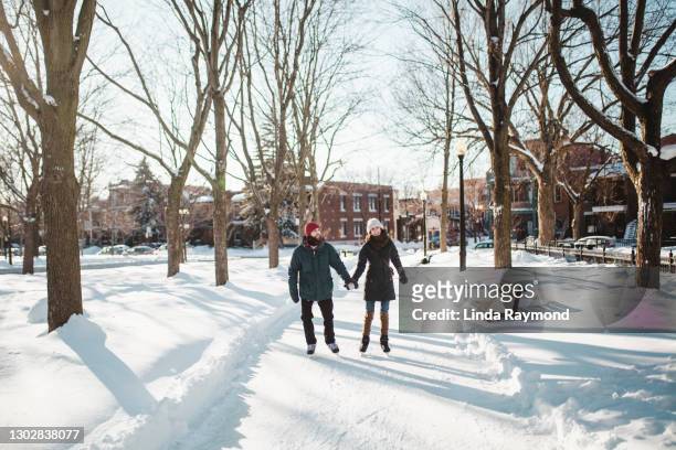 jeune couple patinant sur une patinoire - montréal photos et images de collection
