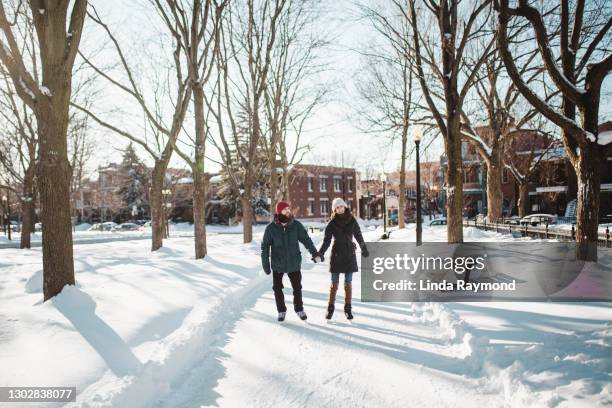 young couple ice-skating on a ice rink - montréal stock pictures, royalty-free photos & images