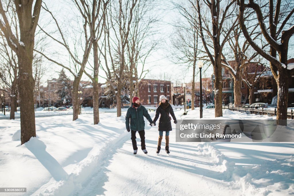 Jovem casal patinando no gelo em uma pista de gelo