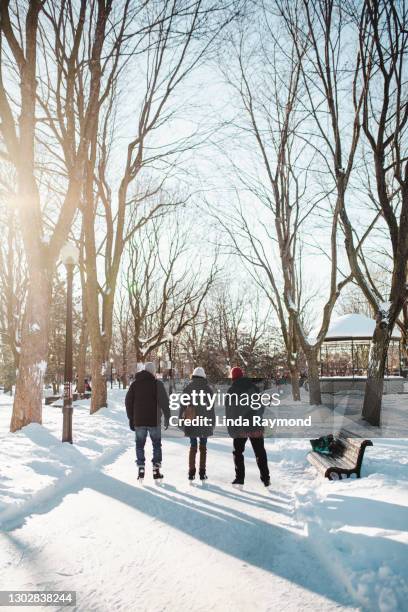 three people ice-skating on a ice rink - solar ice rink stock pictures, royalty-free photos & images
