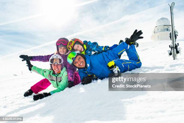 het skiën familie die pret op de winterdag heeft - family in snow mountain stockfoto's en -beelden