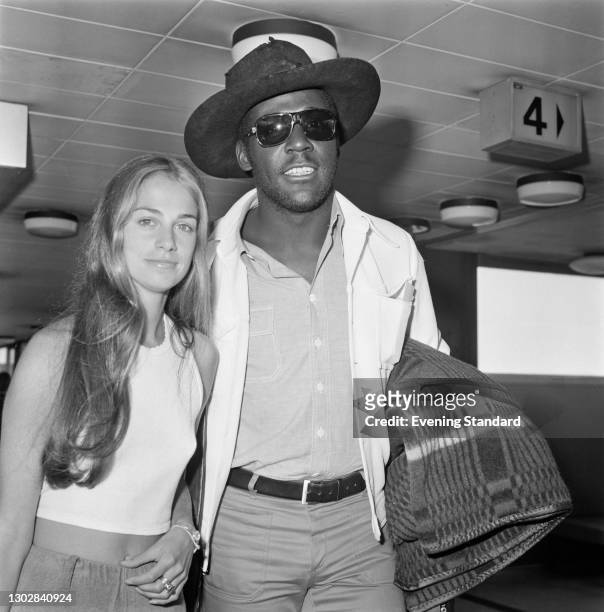 American actor Richard Roundtree at Heathrow Airport in London, with a young woman, UK, 25th July 1972.