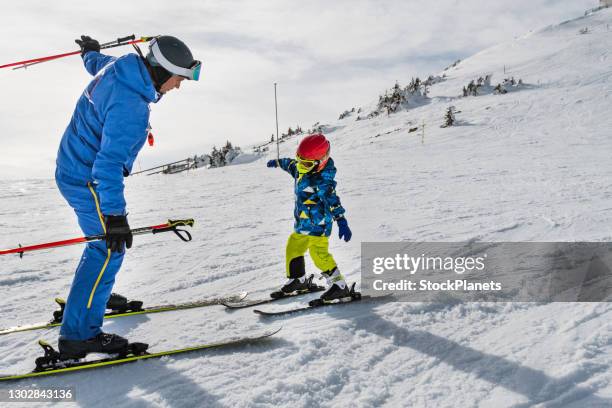 coach teaches the boy to ski on the ski slope - family skiing stock pictures, royalty-free photos & images
