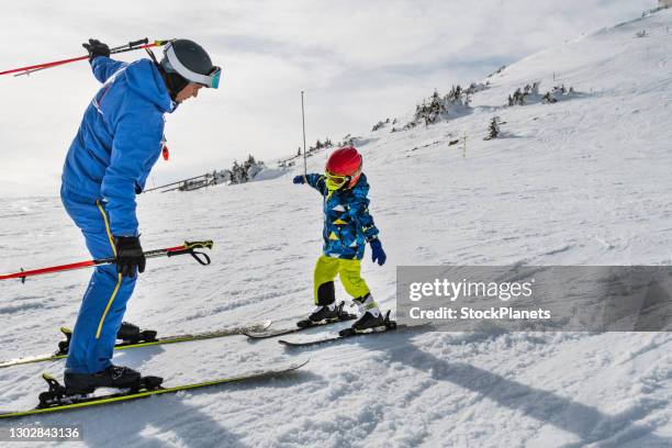 coach teaches the boy to ski on the ski slope - kid skiing stock pictures, royalty-free photos & images