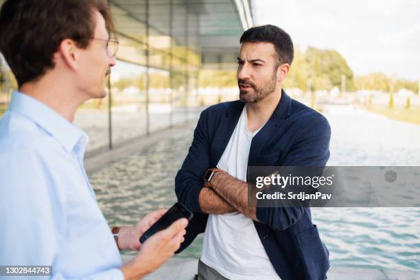 modern coworkers chatting together outside the business building - business talk stock pictures, royalty-free photos & images