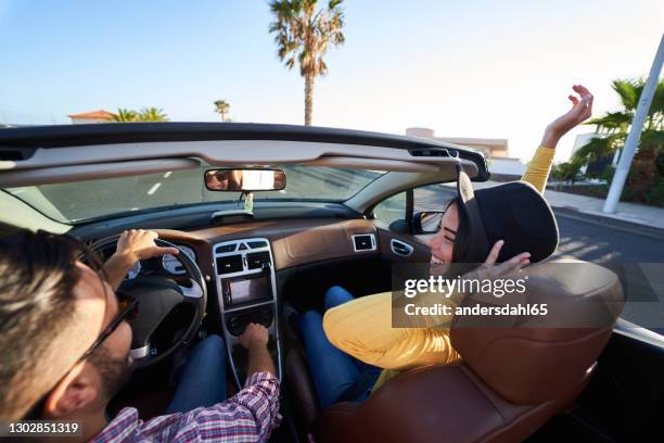 beautiful smiling girl with hat driving in cabriolet car with her boyfriend - andersdahl65 stock pictures, royalty-free photos & images