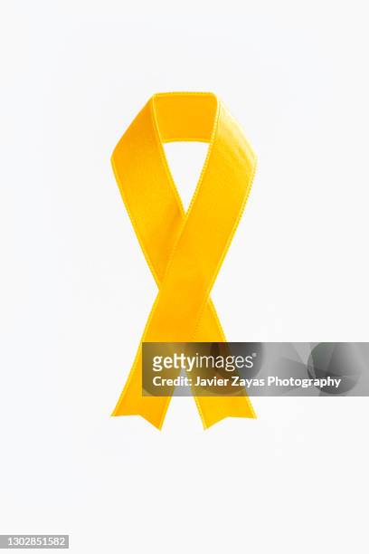 yellow awareness ribbon on white background - yellow ribbon stock pictures, royalty-free photos & images