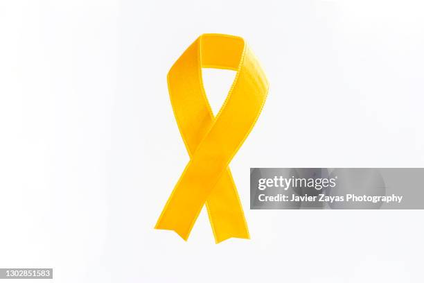 yellow awareness ribbon on white background - yellow september stock pictures, royalty-free photos & images