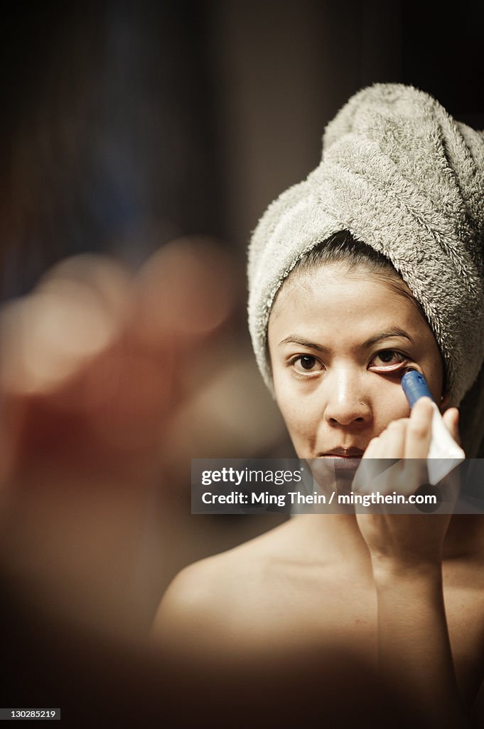 Portrait of girl applying eye cosmetics