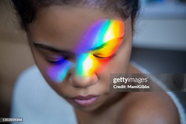 girl's face reflecting the rainbow light - rainbow light reflection stock pictures, royalty-free photos & images