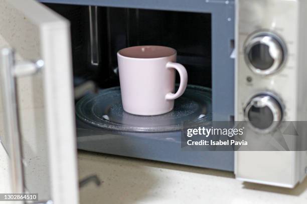 a cup of coffee inside a microwave - microwave dish stock pictures, royalty-free photos & images