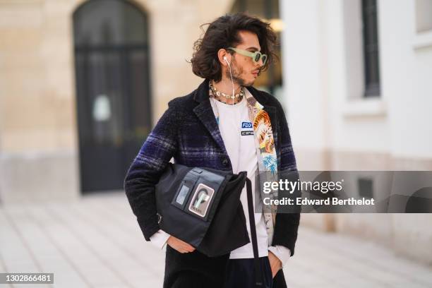 Andree Dubois wears green sunglasses, a sea-shell necklace, a white t-shirt with the printed FDJ Française des Jeux logo and Icepeak logo, a colored...