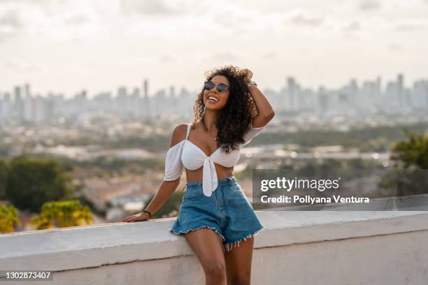 mulher feliz com a mão no cabelo - calção - fotografias e filmes do acervo