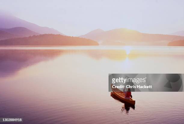 usa, new york, north elba, lake placid, woman canoeing on lake placid - tranquility stock pictures, royalty-free photos & images