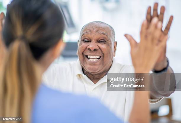 patient and nurse high five! - black man high 5 stock pictures, royalty-free photos & images