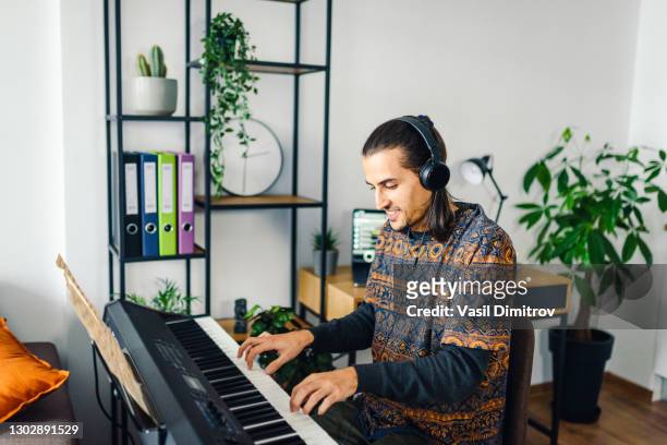 man playing the piano stock photo.  creating / recording music at home concept. - electric piano stock pictures, royalty-free photos & images