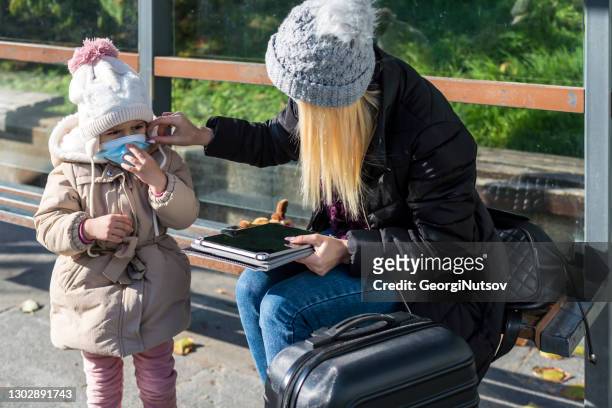 young mother with her daughter waiting for public transport - center street elementary stock pictures, royalty-free photos & images