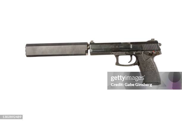 a detailed view of a .45 caliber handgun with a silencer on white background - revolver-with-silencer stock-fotos und bilder