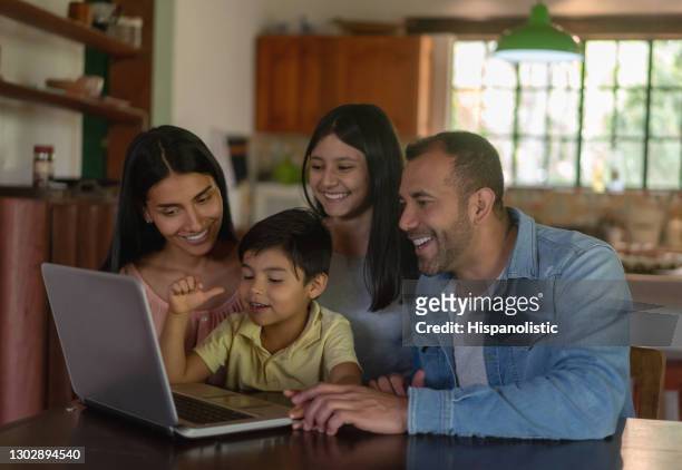 glückliche lateinamerikanische familie auf video-anruf zu hause - lateinamerikaner oder hispanic stock-fotos und bilder