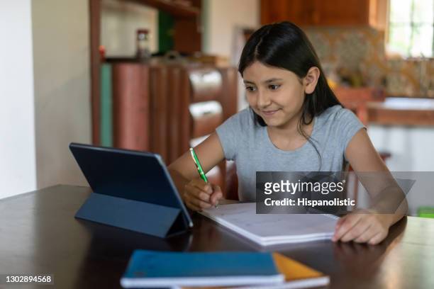 happy latin american girl studying online at home - childhood poverty stock pictures, royalty-free photos & images