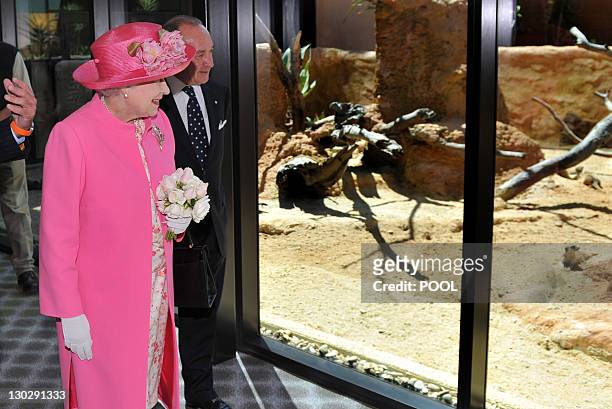 Britain's Queen Elizabeth II inspects the meerkat enclosure with chairman Tony Beddison as she officially opens the new Royal Children's Hospital,...