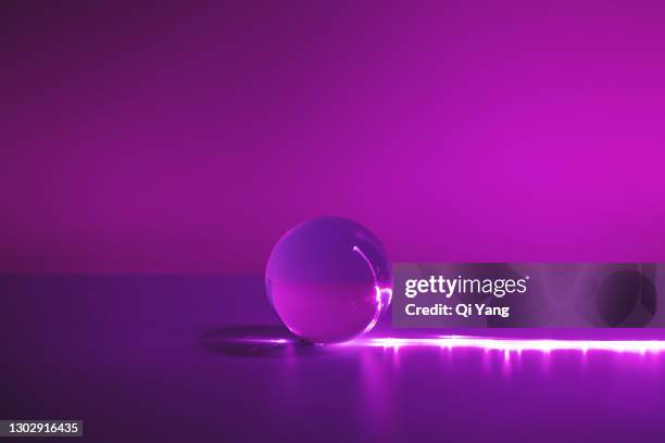 optical fiber illuminates the crystal ball in purple background - lightning purple stock pictures, royalty-free photos & images