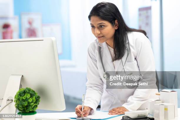 female doctor using desktop pc , stock photo - leaning over stock pictures, royalty-free photos & images