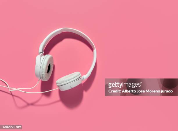 headphones on pink background - headphones fotografías e imágenes de stock