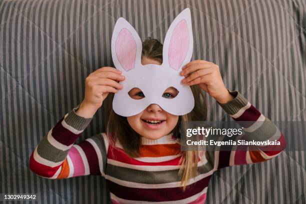 cute little girl wearing rabbit's mask for easter celebration. - rabbit mask fotografías e imágenes de stock