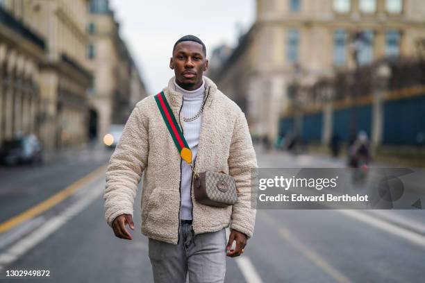 Steevy Mbala aka "sao.cara" wears a white turtleneck pullover from Boohoo, a chain necklace, a white fluffy coat from Boohoo, a Gucci crossbody bag,...