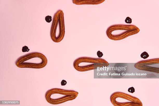 still life of churros with chocolate on a pink background - chocolate con churros stock-fotos und bilder