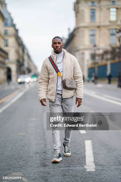 Steevy Mbala aka "sao.cara" wears a white turtleneck pullover from Boohoo, a chain necklace, a white fluffy coat from Boohoo, a Gucci crossbody bag,...