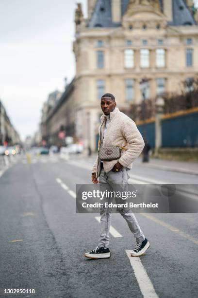 Steevy Mbala aka "sao.cara" wears a white turtleneck pullover from Boohoo, a chain necklace, a white fluffy coat from Boohoo, a Gucci crossbody bag,...