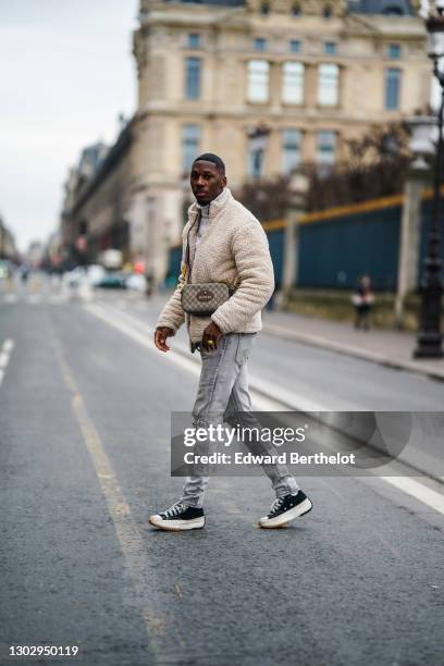 Steevy Mbala aka "sao.cara" wears a white turtleneck pullover from Boohoo, a chain necklace, a white fluffy coat from Boohoo, a Gucci crossbody bag,...