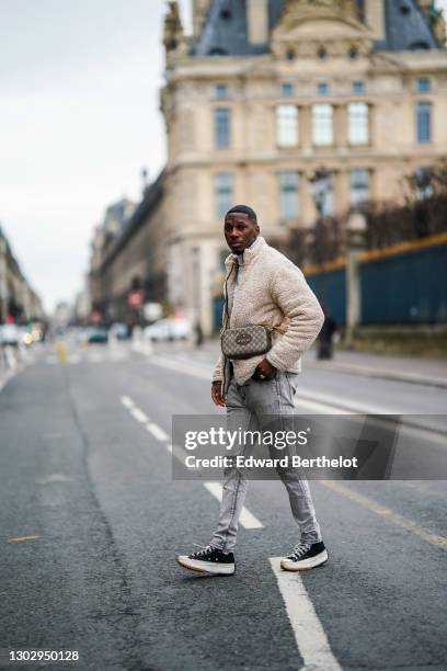 Steevy Mbala aka "sao.cara" wears a white turtleneck pullover from Boohoo, a chain necklace, a white fluffy coat from Boohoo, a Gucci crossbody bag,...