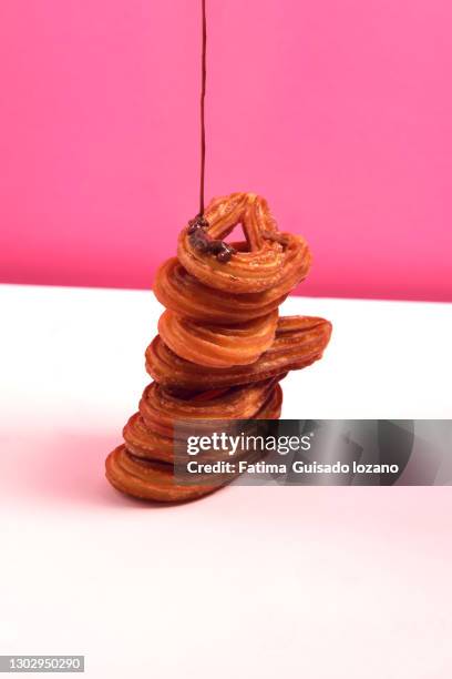 still life of churros with chocolate on a pink background - chocolate con churros stock-fotos und bilder