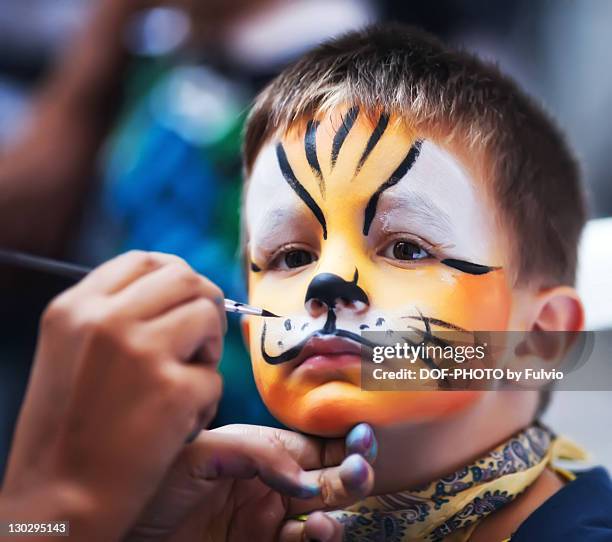 boy masked as tiger - geschminkt gezicht stockfoto's en -beelden