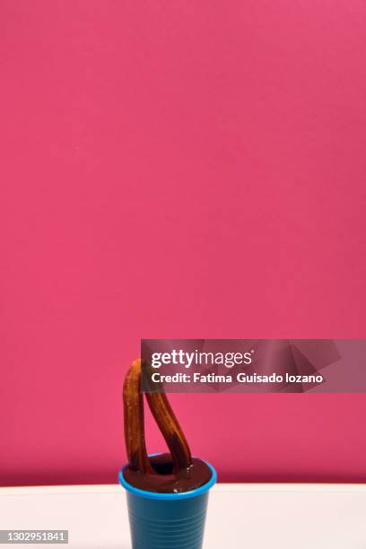 still life of churros with chocolate on a pink background - chocolate con churros stock pictures, royalty-free photos & images