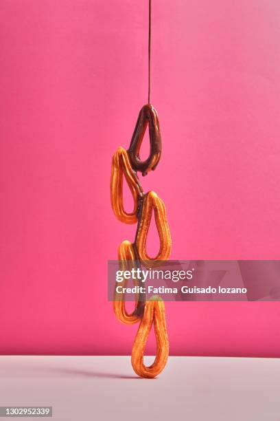 still life of churros with chocolate on a pink background - chocolate con churros stock-fotos und bilder