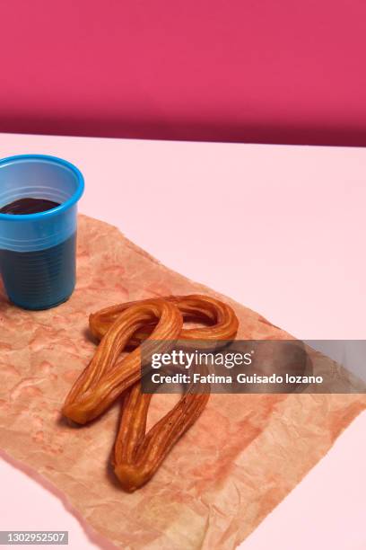 still life of churros with chocolate on a pink background - chocolate con churros stock pictures, royalty-free photos & images