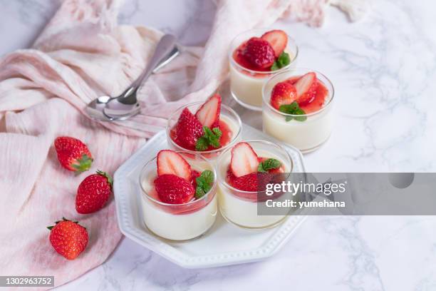 panna cotta crémeuse de yaourt avec la sauce fraîche de fraise dans le verre sur un fond de marbre. - panna cotta photos et images de collection
