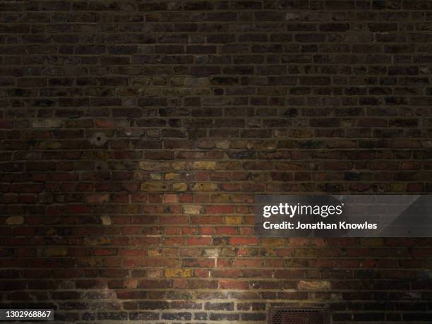 low lit brick wall - brique photos et images de collection