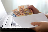 Envelope with euro banknotes in female hands