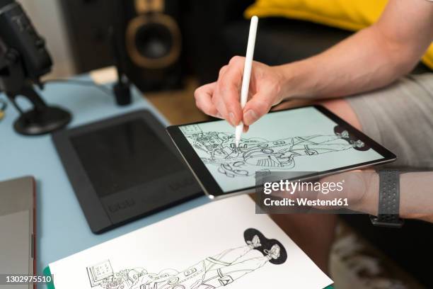 artist drawing on digital tablet while live streaming sitting at home - caricaturista fotografías e imágenes de stock